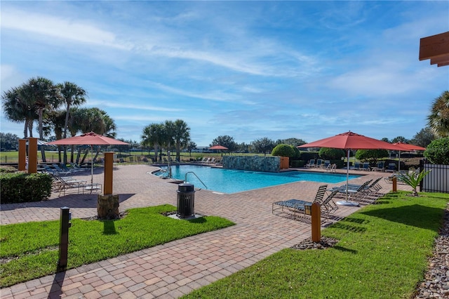 view of swimming pool with a lawn, a patio, and pool water feature