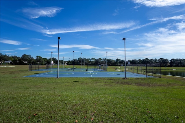 view of basketball court with a water view, a yard, and tennis court