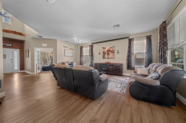 living room with wood-type flooring and a textured ceiling