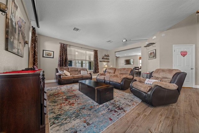 living room featuring light hardwood / wood-style floors and a textured ceiling