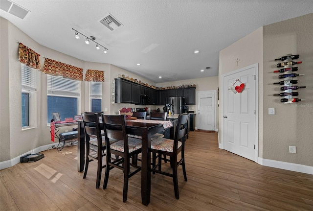 dining room featuring dark hardwood / wood-style flooring and a textured ceiling