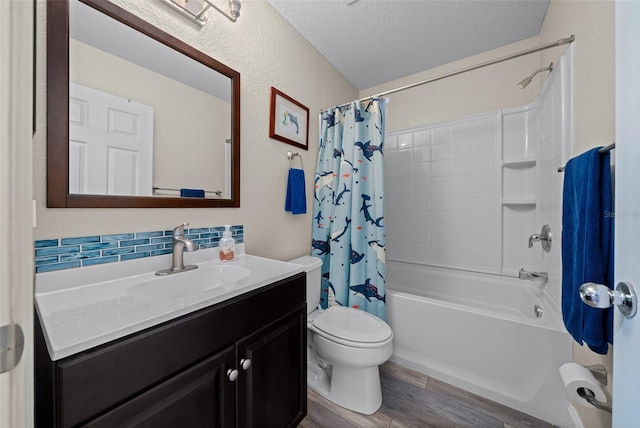 full bathroom with shower / tub combo, vanity, wood-type flooring, a textured ceiling, and toilet