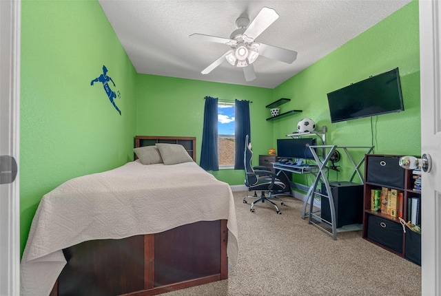 bedroom with ceiling fan, carpet floors, and a textured ceiling