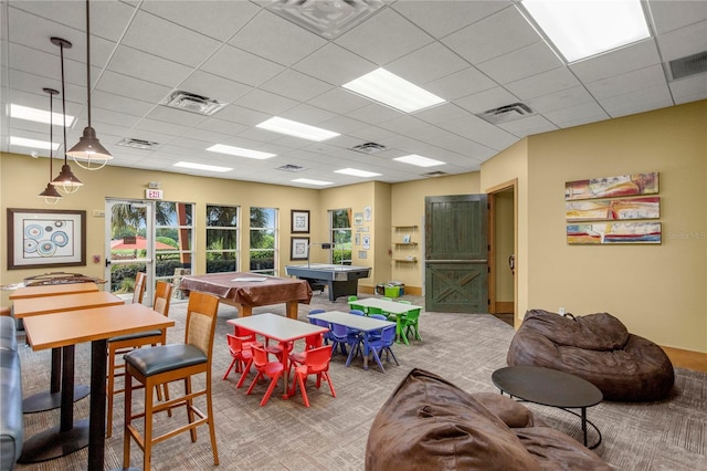 recreation room with light carpet and a drop ceiling