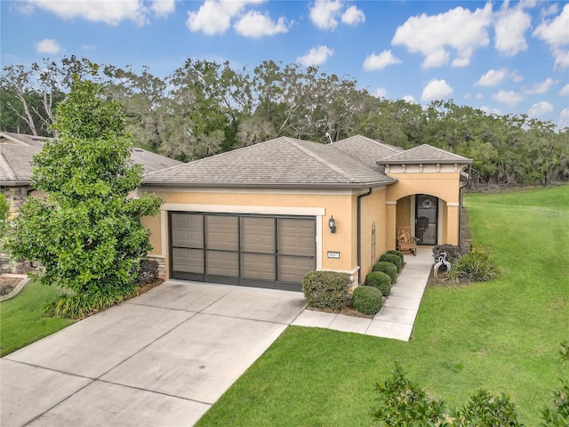 view of front of property with a garage and a front lawn