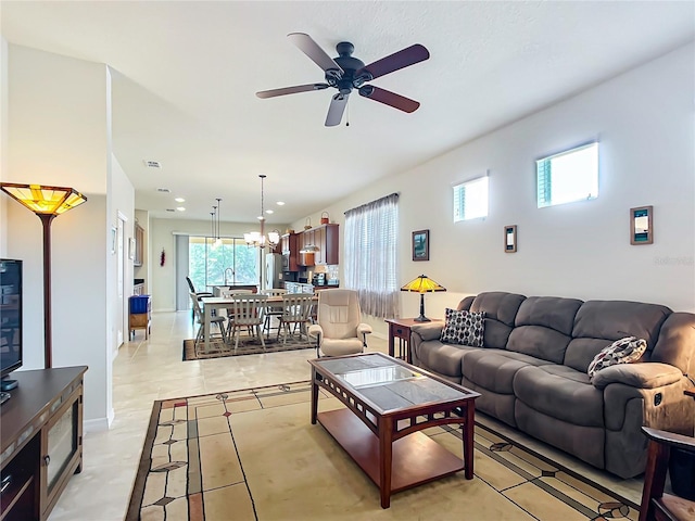 living room with ceiling fan with notable chandelier