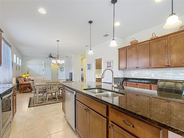 kitchen featuring pendant lighting, appliances with stainless steel finishes, sink, and dark stone counters