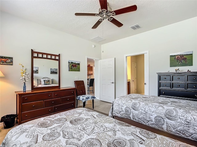 bedroom featuring ceiling fan, vaulted ceiling, and a textured ceiling