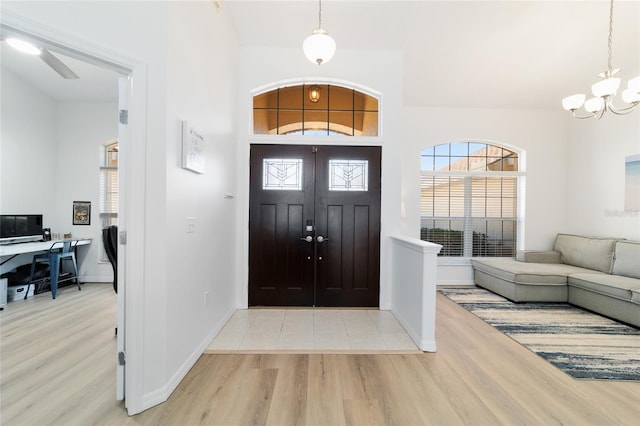 foyer featuring light wood-type flooring and a notable chandelier