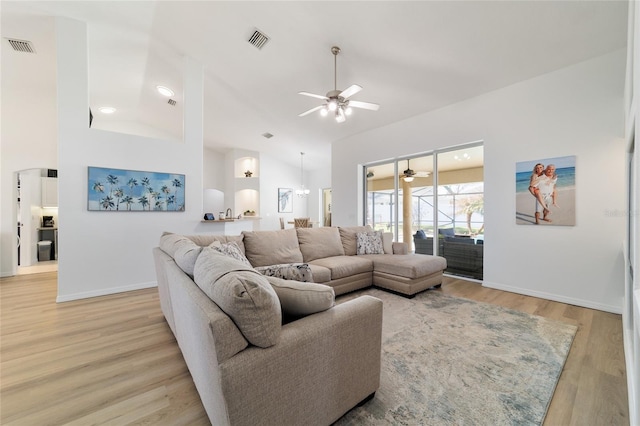 living room with ceiling fan, high vaulted ceiling, and light wood-type flooring