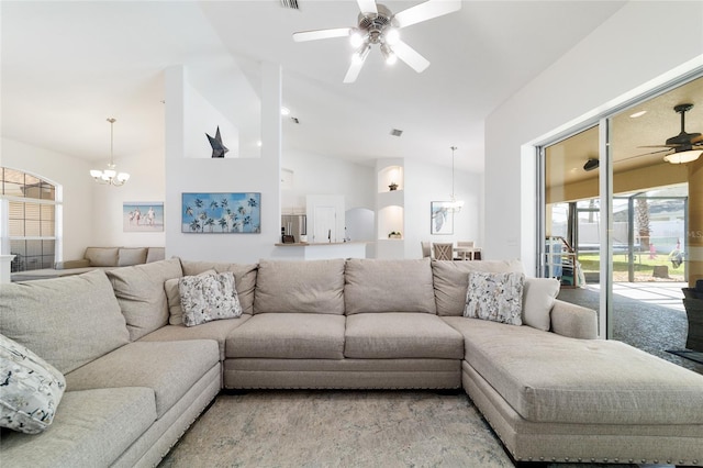 living room featuring vaulted ceiling and ceiling fan with notable chandelier