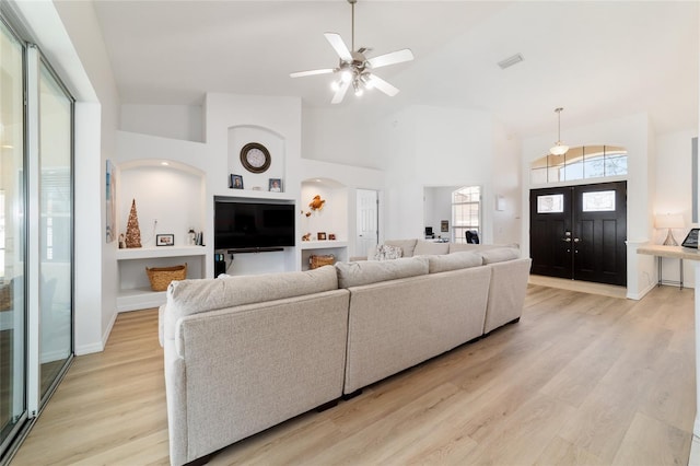 living room featuring ceiling fan, high vaulted ceiling, and light hardwood / wood-style flooring