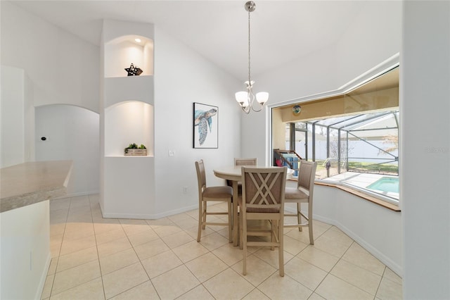 tiled dining room featuring a chandelier and high vaulted ceiling