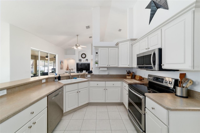 kitchen with appliances with stainless steel finishes, sink, white cabinets, ceiling fan, and kitchen peninsula