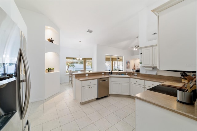 kitchen featuring sink, vaulted ceiling, kitchen peninsula, stainless steel appliances, and white cabinets