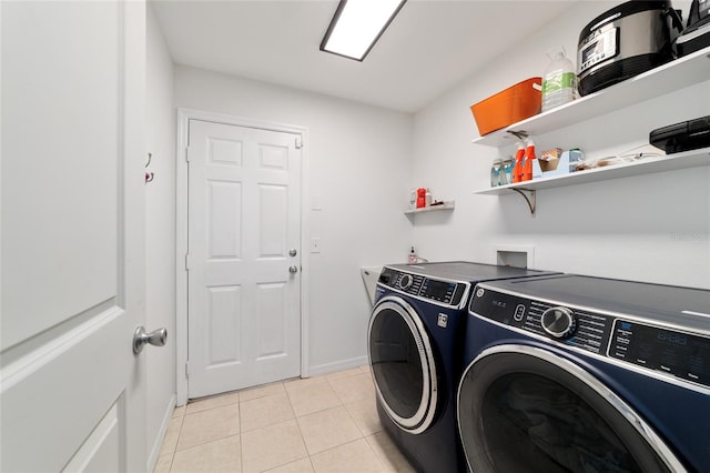 washroom with light tile patterned floors and washer and clothes dryer