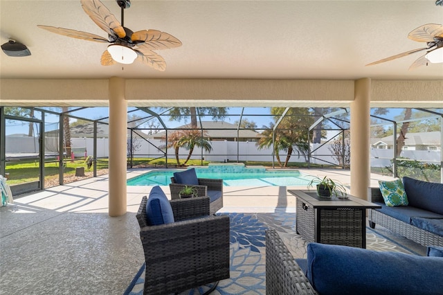 exterior space featuring outdoor lounge area, a patio, ceiling fan, and glass enclosure