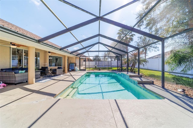 view of pool with ceiling fan, a lanai, and a patio area