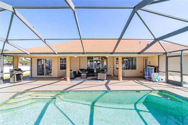 view of pool with a grill, outdoor lounge area, a patio area, and glass enclosure