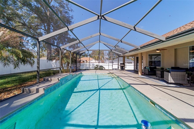 view of pool with a patio, outdoor lounge area, area for grilling, ceiling fan, and glass enclosure