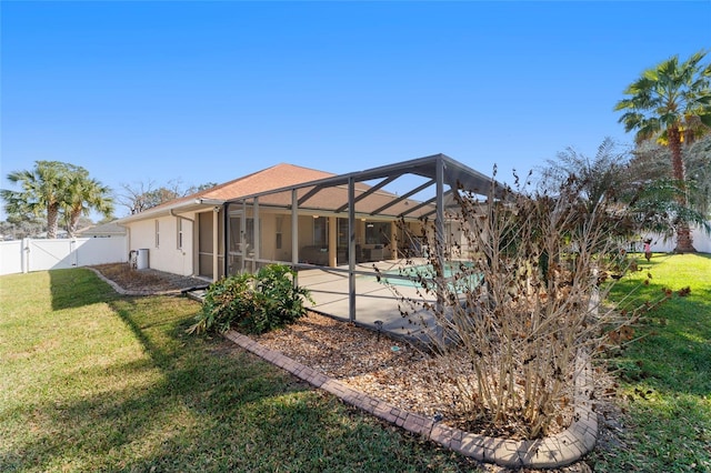 rear view of house with a yard, a lanai, a patio, and a fenced in pool