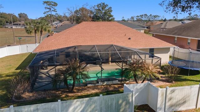 back of house with a fenced in pool, a lanai, and a lawn