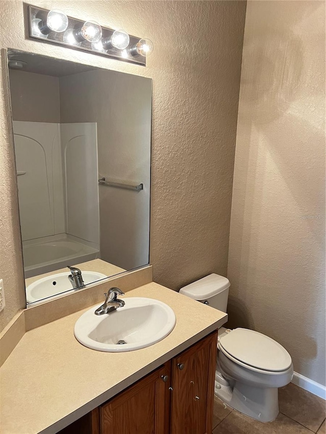 full bathroom featuring toilet, tile patterned flooring, vanity, and a textured wall