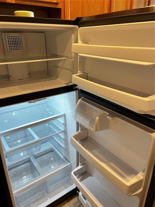 interior details with brown cabinetry and fridge