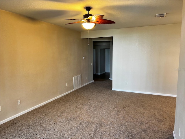 carpeted spare room featuring a ceiling fan, visible vents, and baseboards