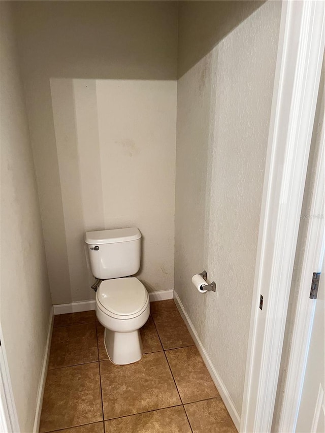 bathroom with tile patterned flooring, toilet, and baseboards