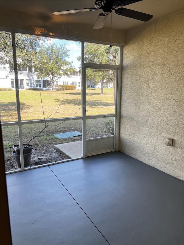 unfurnished sunroom with a ceiling fan