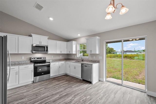 kitchen featuring white cabinetry, sink, hanging light fixtures, stainless steel appliances, and light stone countertops