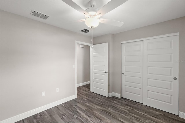 unfurnished bedroom featuring dark wood-type flooring, ceiling fan, and a closet