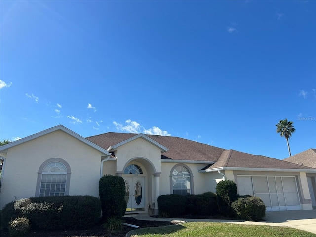 5500 NW 23rd Pl, Ocala, FL 34482 - ranch-style home featuring french doors, a garage, concrete driveway, a shingled roof, and stucco siding