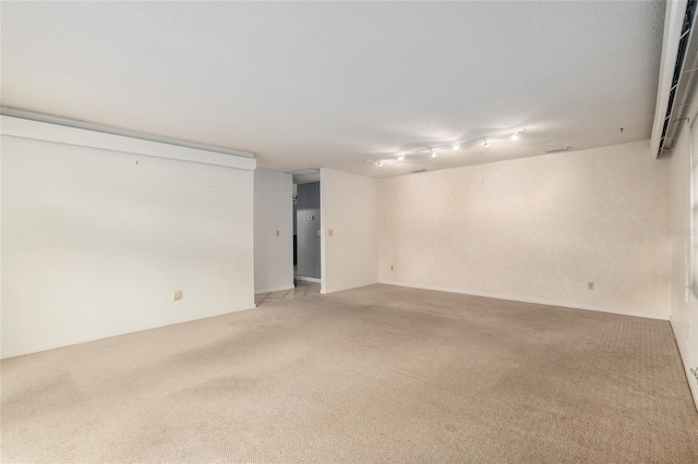 empty room featuring light colored carpet and a textured ceiling