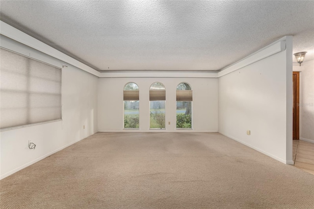 carpeted empty room featuring a textured ceiling