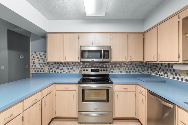 kitchen with backsplash, light brown cabinets, and appliances with stainless steel finishes