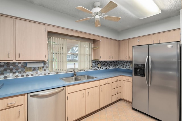 kitchen featuring stainless steel appliances, sink, light brown cabinets, and a textured ceiling