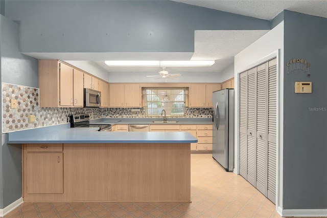 kitchen featuring appliances with stainless steel finishes, light brown cabinetry, and kitchen peninsula