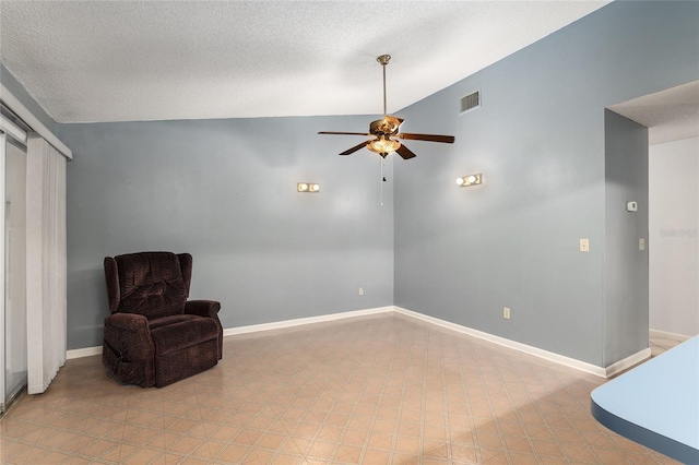 sitting room featuring ceiling fan, lofted ceiling, and a textured ceiling