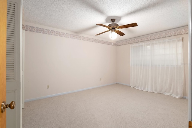 carpeted empty room with ceiling fan and a textured ceiling