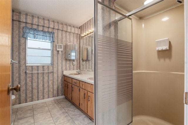 bathroom with vanity, a shower with door, tile patterned floors, and toilet