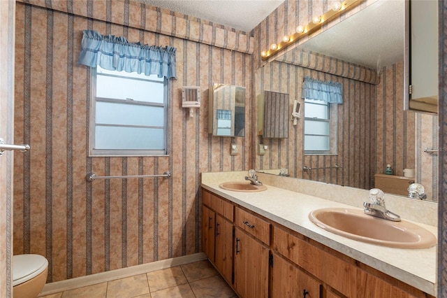 bathroom featuring tile patterned flooring, vanity, a healthy amount of sunlight, and toilet