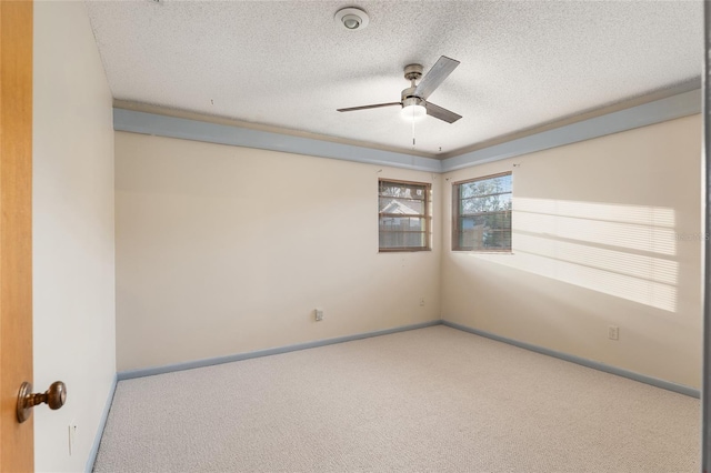 carpeted spare room featuring ceiling fan and a textured ceiling