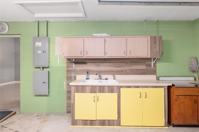 kitchen with electric panel, sink, and a textured ceiling