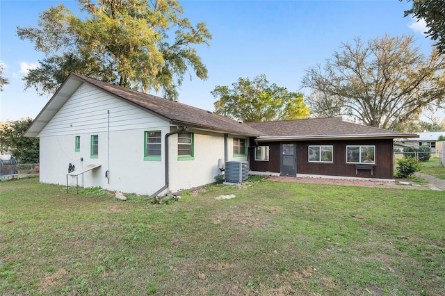 view of front of home with central AC unit and a front yard