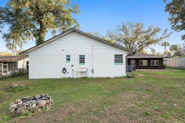 back of house featuring a yard and central AC