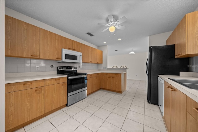 912 Chula Ct, Lady Lake, FL 32159 - kitchen with light tile patterned flooring, sink, tasteful backsplash, ceiling fan, and white appliances