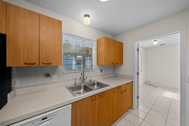 912 Chula Ct, Lady Lake, FL 32159 - kitchen with sink, a textured ceiling, light tile patterned floors, dishwasher, and backsplash