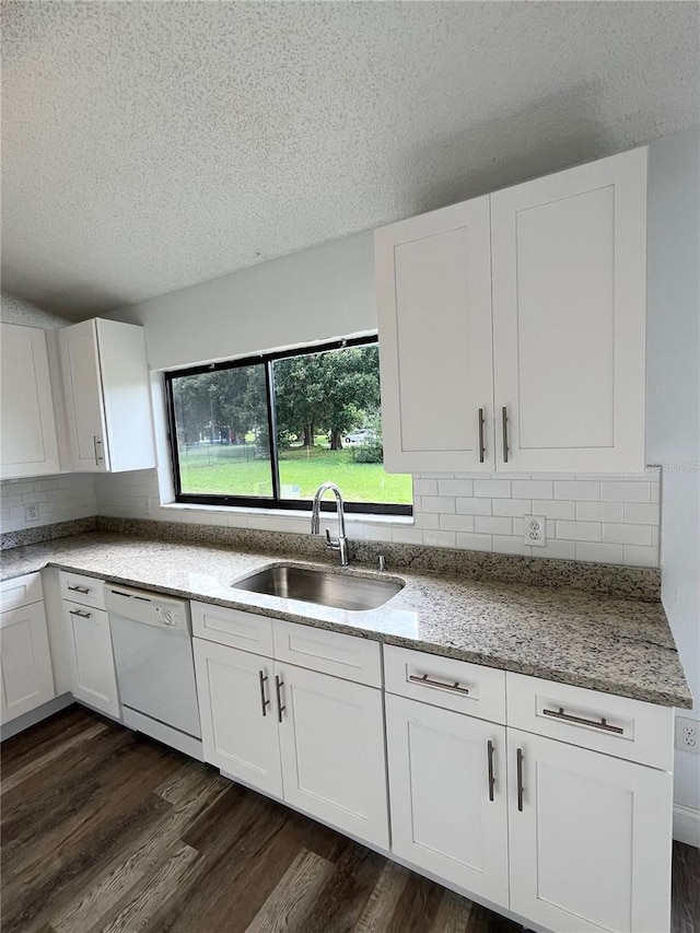 kitchen featuring dark hardwood / wood-style floors, dishwasher, sink, white cabinets, and light stone countertops